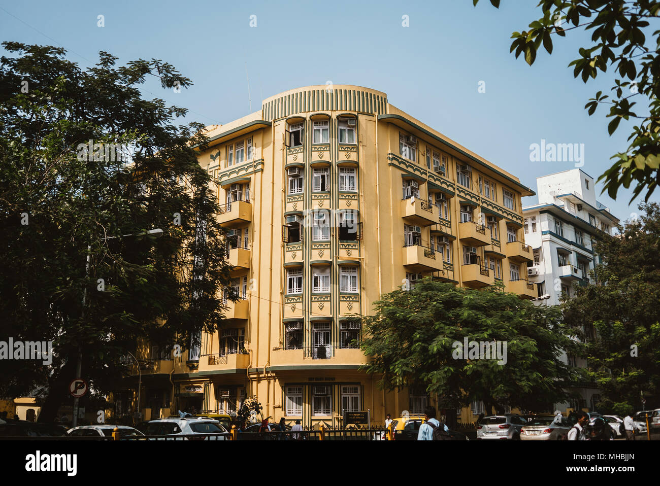 Gelb Art Deco Apartment Komplex auf baumreihen Ecke in Mumbai, Indien Stockfoto