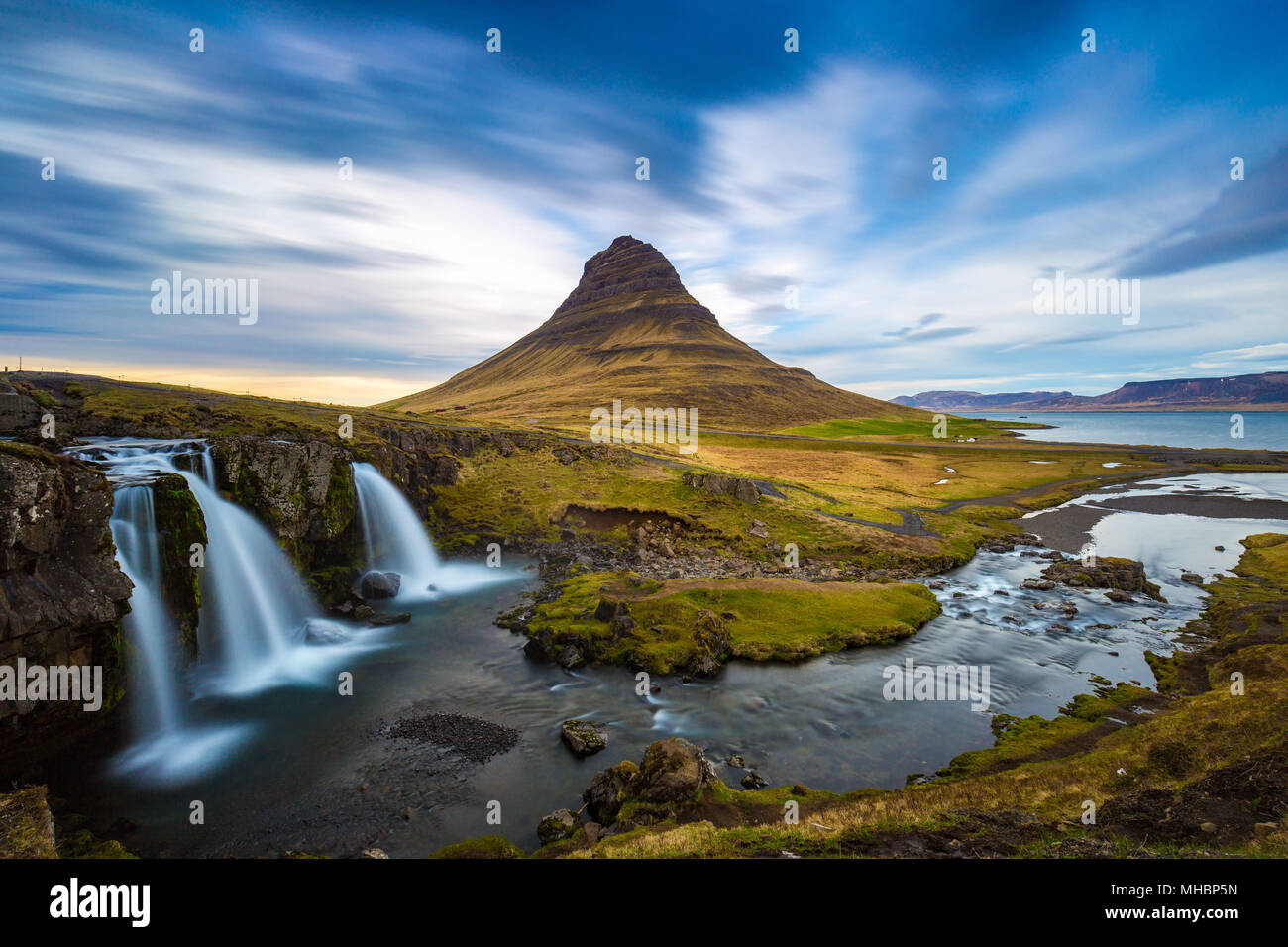 Kirkjufellsfoss Wasserfall mit Kirkjufell Berg im Hintergrund bei Sonnenuntergang, Island Stockfoto