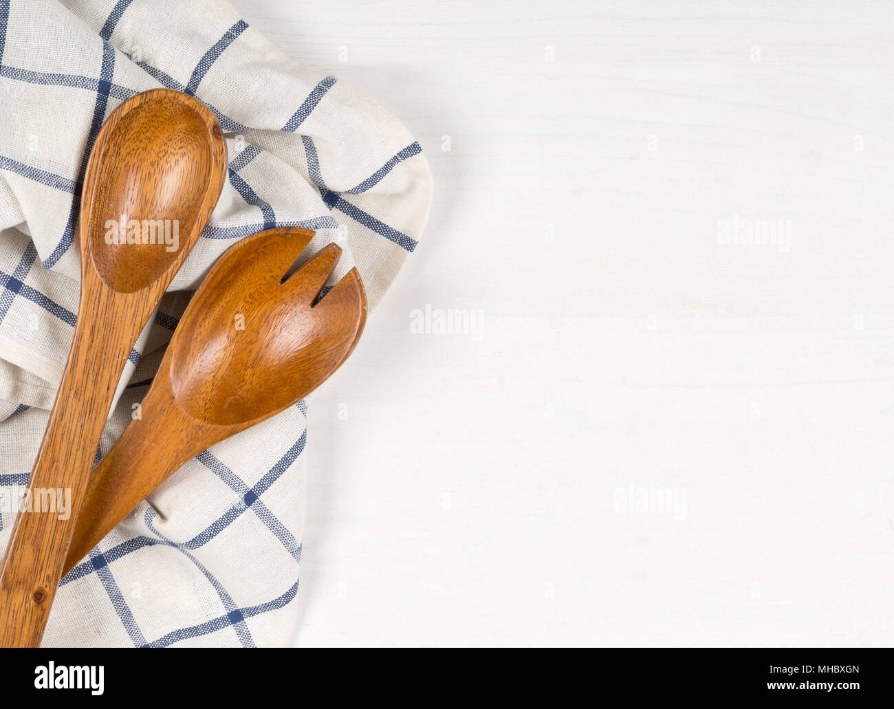 Holzlöffel mit blauen und weißen Küchentuch auf weissem Holztisch mit Kopie Raum Stockfoto