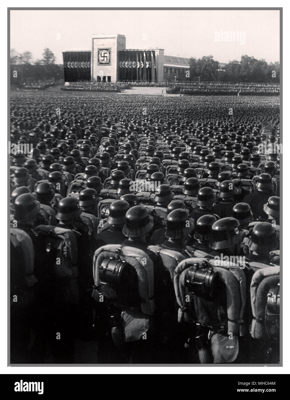 Ns-Waffen-SS-Truppen in polierten Helme in präzise serried Rank an Salute stehen während eines deutschen Nazi Kundgebung vor dem Zweiten Weltkrieg Nürnberg 1930 Stockfoto