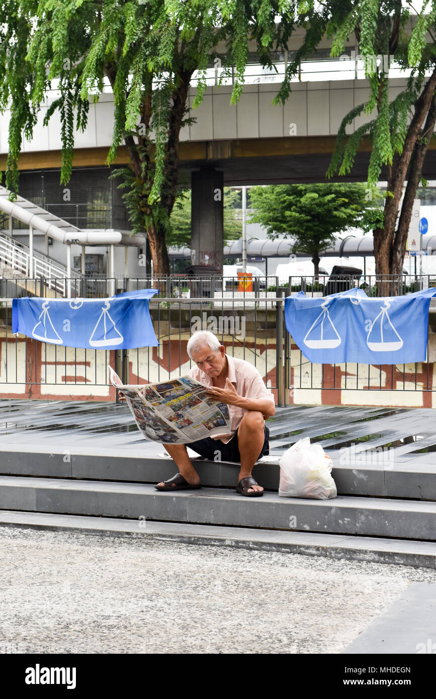 Mann liest Zeitung, Kuala Lumpur Stockfoto