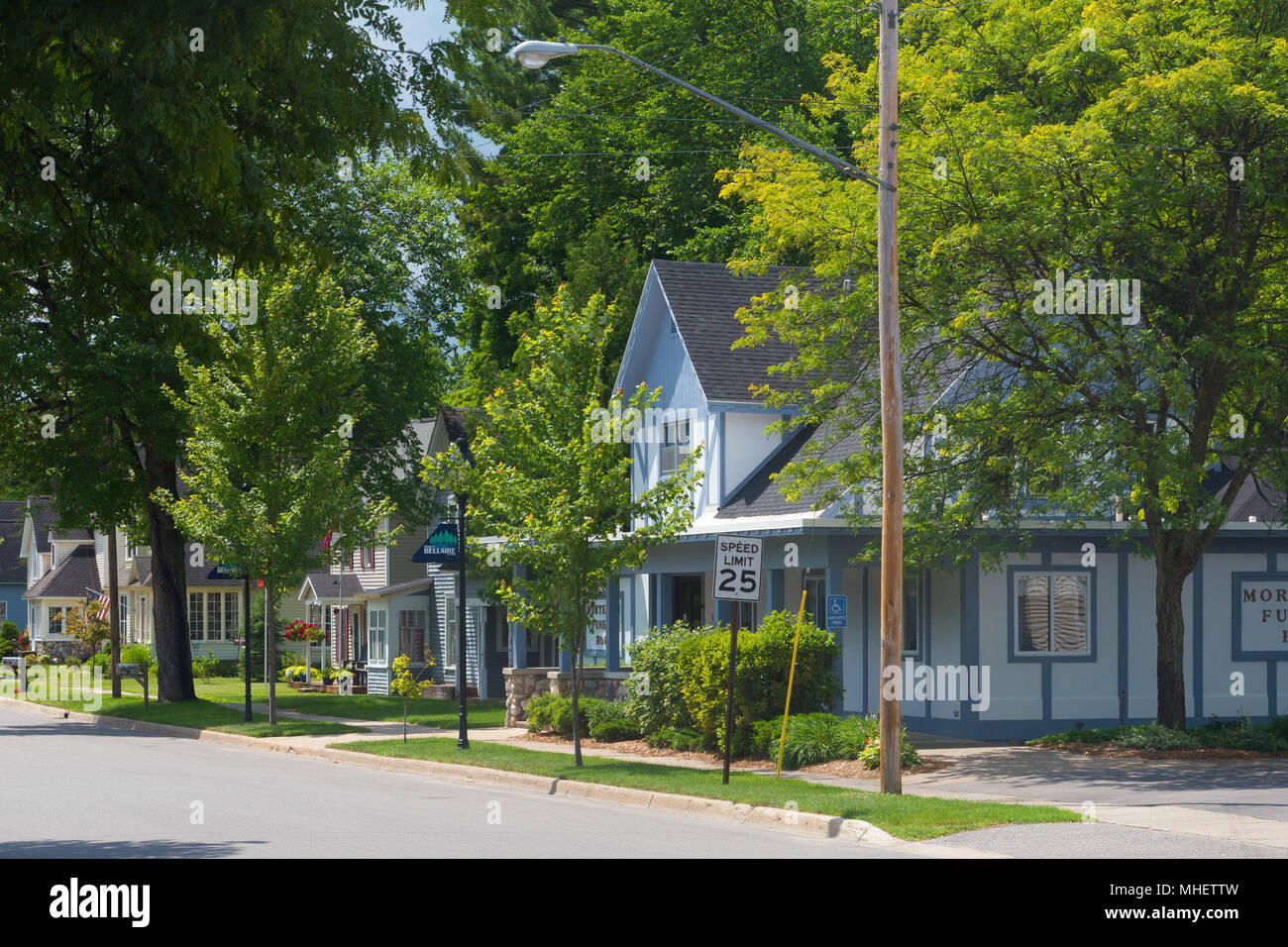 Eine Reihe von Häusern auf einer Vorstadtstraße in dem Dorf Bellaire in Michigan, USA. Stockfoto