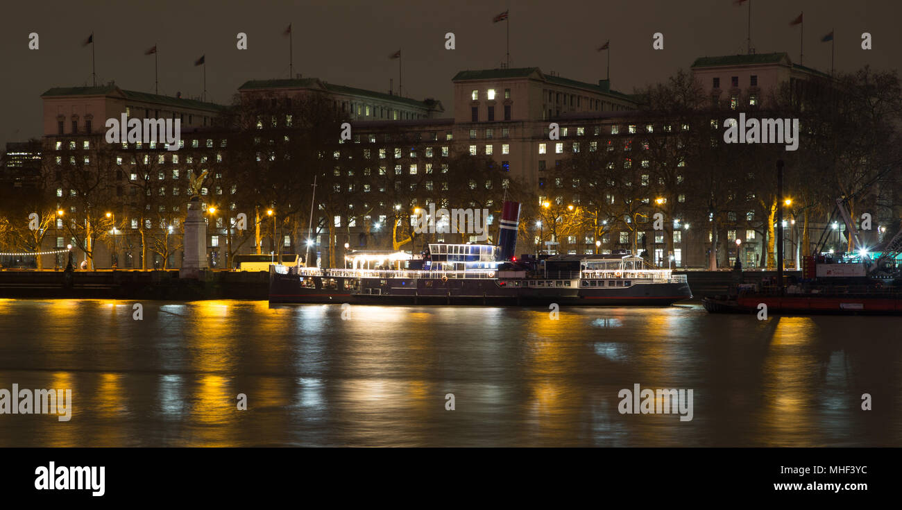 Nacht Blick auf die Themse, London mit einer Party Boot und MoD (Ministerium für Verteidigung) Gebäude, die RAF Memorial Stockfoto