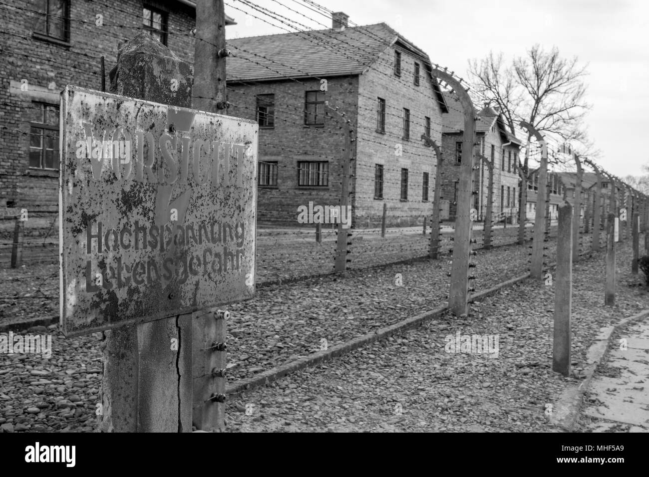 Auschwitz, Polen. Innerhalb der deutschen Konzentrationslager Auschwitz (Oswiecim), zeigt hohe Spannung Warnzeichen gegen den Stacheldrahtzaun Stockfoto