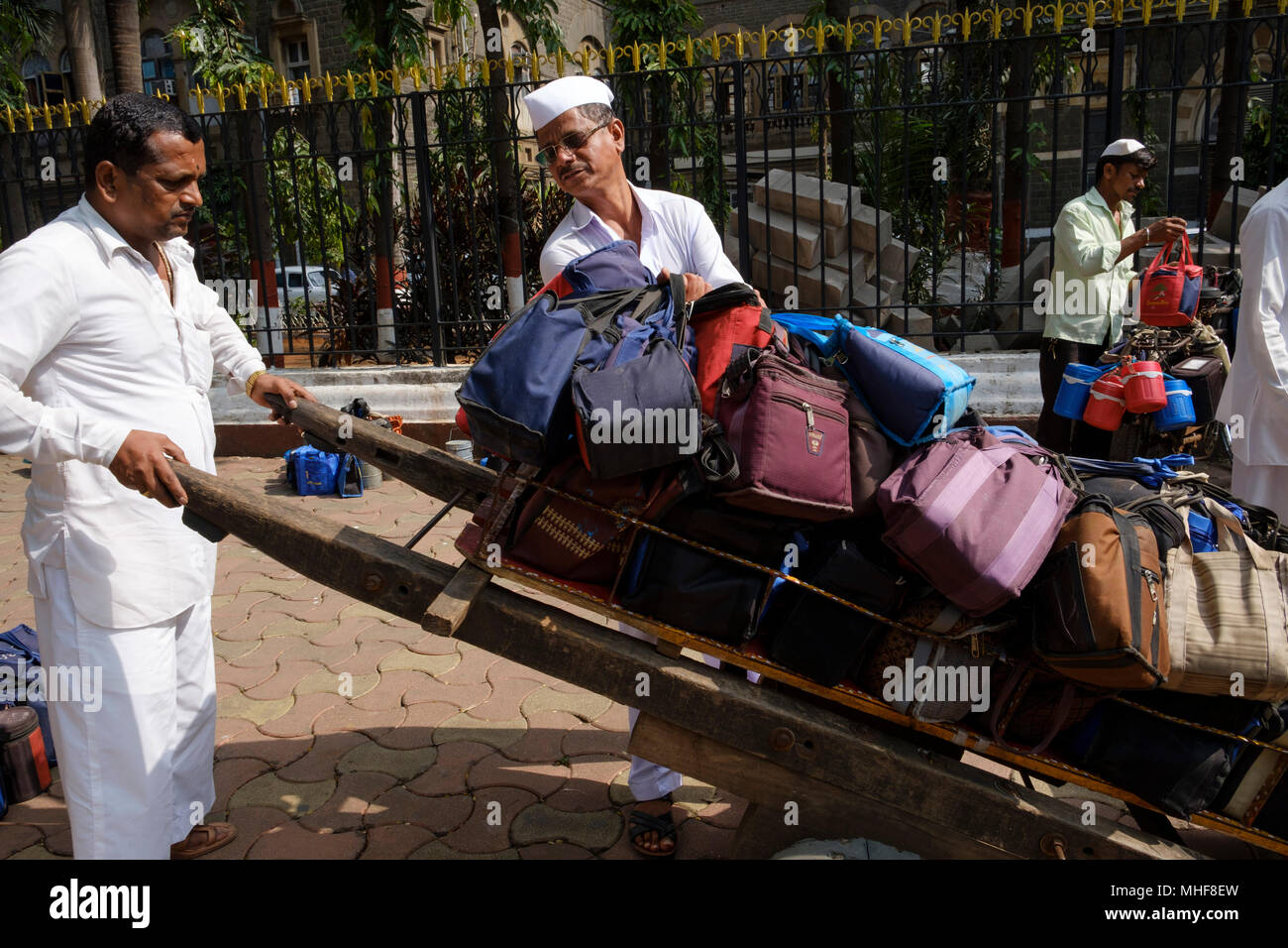 Einige der 5.000 Dabbawalas, in den obligatorischen weißen Gandhi caps Vorbereitung von 130.000 Lunchboxen zu Büros geliefert, jeden Morgen zu liefern gekleidet und nach Hause zurückgekehrt, jeden Nachmittag, 6 Tage die Woche, 51 Wochen im Jahr. Der Dienst bietet Hausmannskost von zu Hause ins Büro geliefert und wieder zurück nach Hause. Der Service ist beansprucht weniger als 1 Fehler in 6 Million Lieferungen zu machen. Mumbai, Indien. Foto von Mike Abrahams Stockfoto