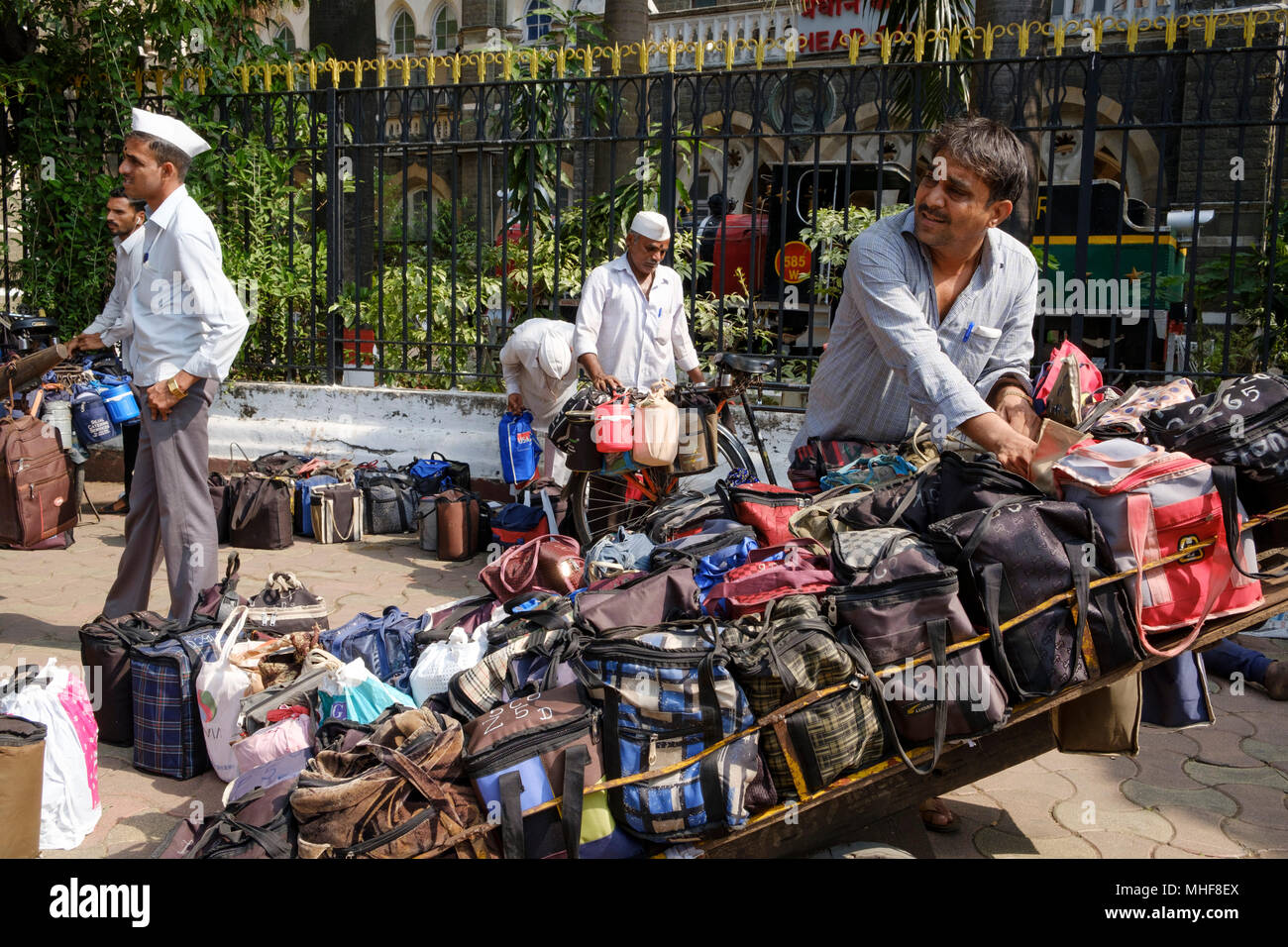 Einige der 5.000 Dabbawalas, in den obligatorischen weißen Gandhi caps Vorbereitung von 130.000 Lunchboxen zu Büros geliefert, jeden Morgen zu liefern gekleidet und nach Hause zurückgekehrt, jeden Nachmittag, 6 Tage die Woche, 51 Wochen im Jahr. Der Dienst bietet Hausmannskost von zu Hause ins Büro geliefert und wieder zurück nach Hause. Der Service ist beansprucht weniger als 1 Fehler in 6 Million Lieferungen zu machen. Mumbai, Indien. Foto von Mike Abrahams Stockfoto