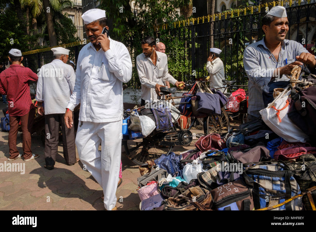 Einige der 5.000 Dabbawalas, in den obligatorischen weißen Gandhi caps Vorbereitung von 130.000 Lunchboxen zu Büros geliefert, jeden Morgen zu liefern gekleidet und nach Hause zurückgekehrt, jeden Nachmittag, 6 Tage die Woche, 51 Wochen im Jahr. Der Dienst bietet Hausmannskost von zu Hause ins Büro geliefert und wieder zurück nach Hause. Der Service ist beansprucht weniger als 1 Fehler in 6 Million Lieferungen zu machen. Mumbai, Indien. Foto von Mike Abrahams Stockfoto