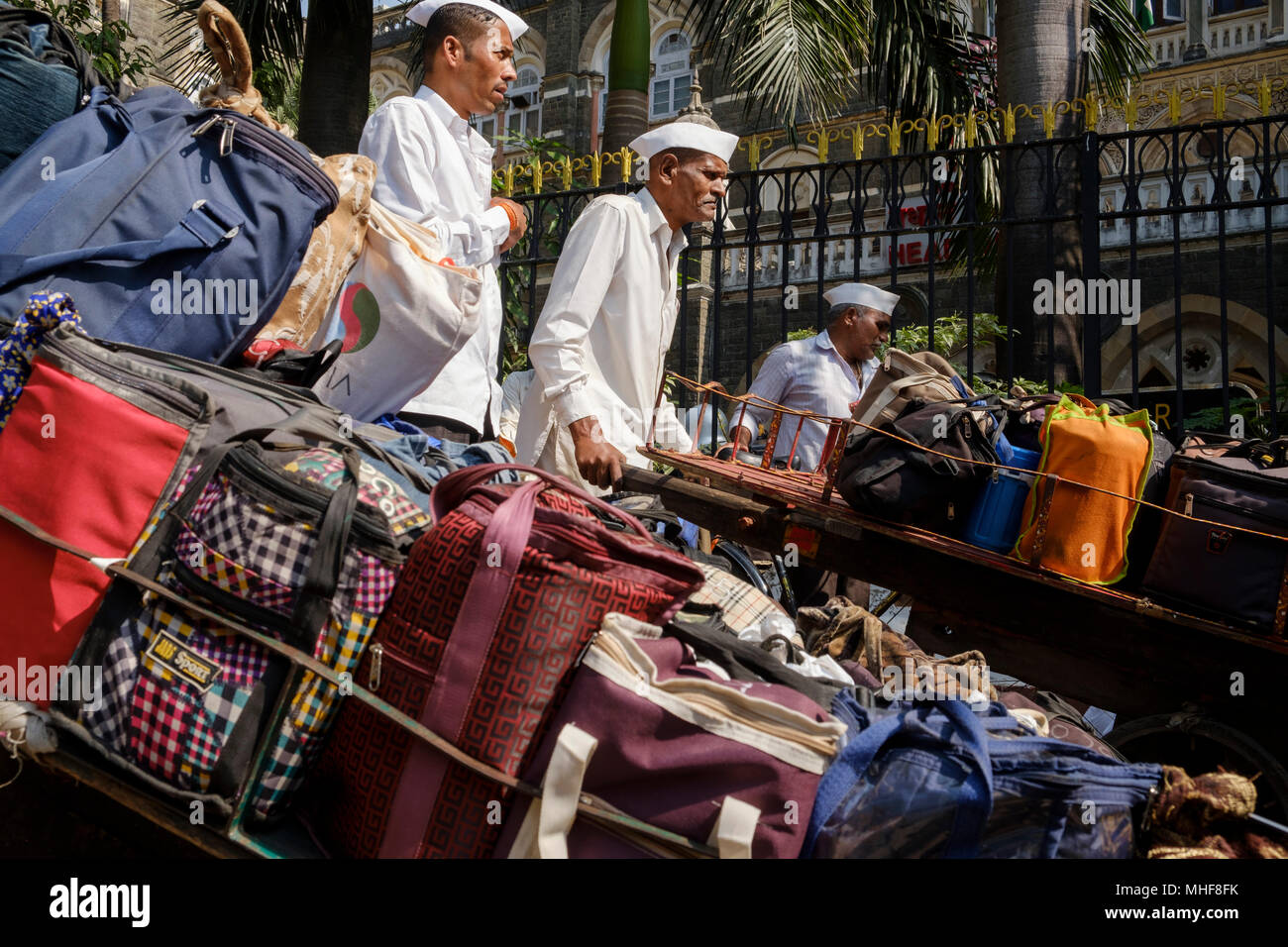 Einige der 5.000 Dabbawalas, in den obligatorischen weißen Gandhi caps Vorbereitung von 130.000 Lunchboxen zu Büros geliefert, jeden Morgen zu liefern gekleidet und nach Hause zurückgekehrt, jeden Nachmittag, 6 Tage die Woche, 51 Wochen im Jahr. Der Dienst bietet Hausmannskost von zu Hause ins Büro geliefert und wieder zurück nach Hause. Der Service ist beansprucht weniger als 1 Fehler in 6 Million Lieferungen zu machen. Mumbai, Indien. Foto von Mike Abrahams Stockfoto