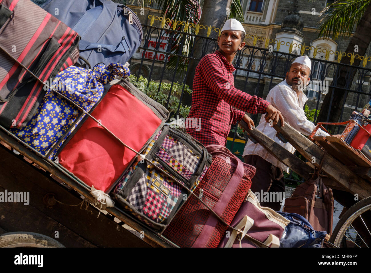 Einige der 5.000 Dabbawalas, in den obligatorischen weißen Gandhi caps Vorbereitung von 130.000 Lunchboxen zu Büros geliefert, jeden Morgen zu liefern gekleidet und nach Hause zurückgekehrt, jeden Nachmittag, 6 Tage die Woche, 51 Wochen im Jahr. Der Dienst bietet Hausmannskost von zu Hause ins Büro geliefert und wieder zurück nach Hause. Der Service ist beansprucht weniger als 1 Fehler in 6 Million Lieferungen zu machen. Mumbai, Indien. Foto von Mike Abrahams Stockfoto