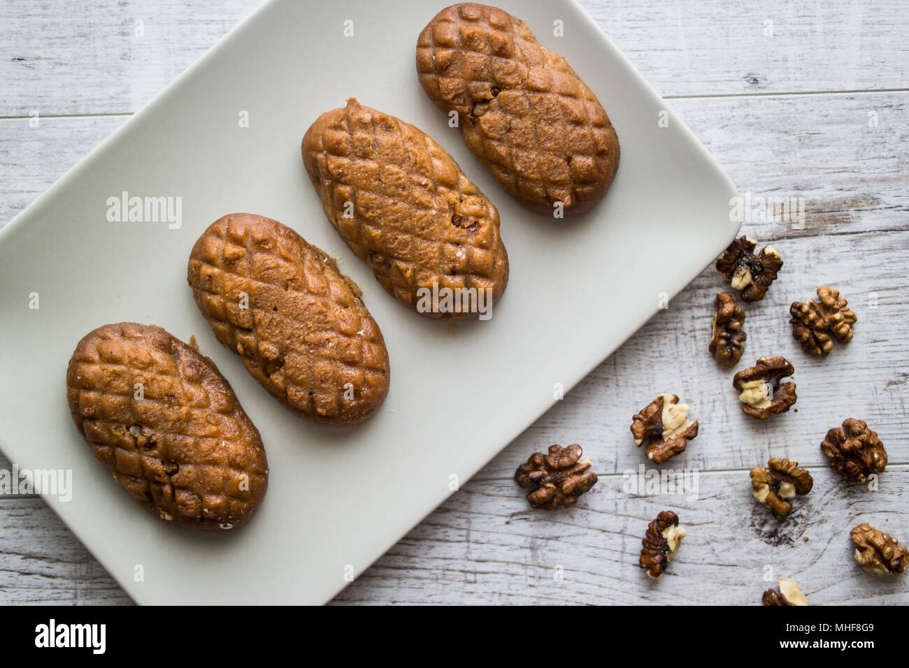 Türkisches Dessert Kalburabasti/Sekerpare mit wallnuts in eine weiße Platte. Stockfoto