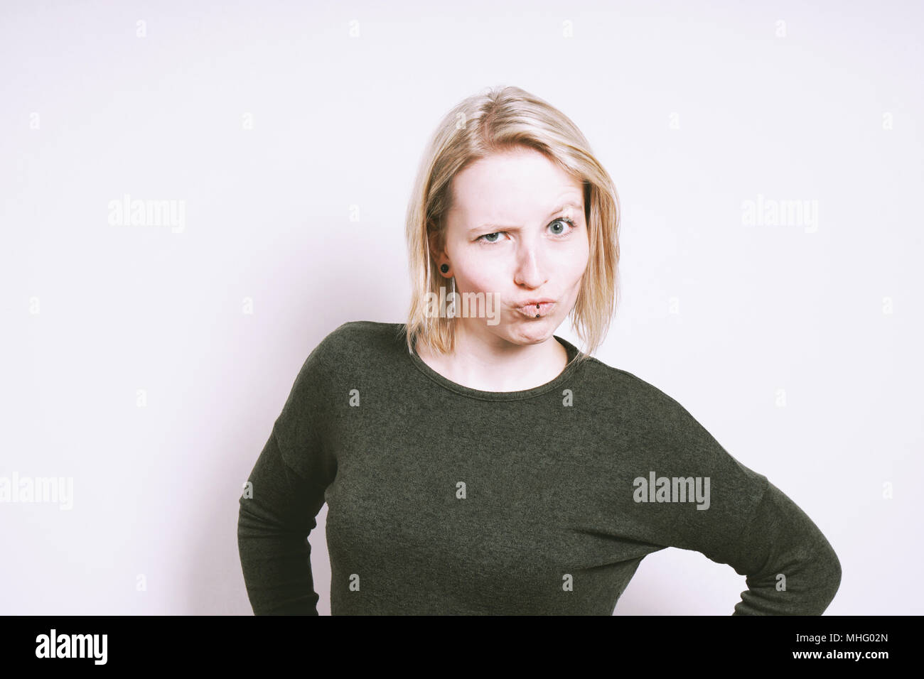 Skeptisch junge Frau Grimassen machen ein lustiges Gesicht Stockfoto