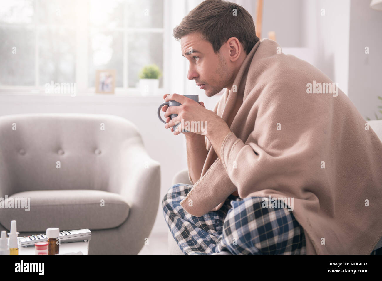 Schön kranken Mann hält eine Tasse mit Kaffee Stockfoto