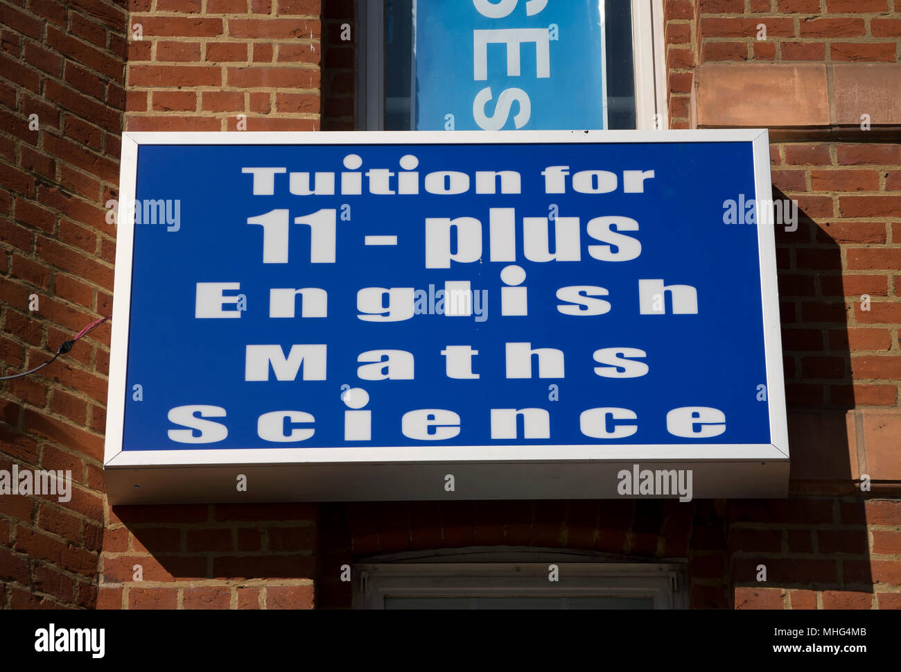 Die Studiengebühren für 11 plus Englisch, Mathematik und Naturwissenschaften, Werbung auf einem Gebäude in Hounslow, London, England Stockfoto