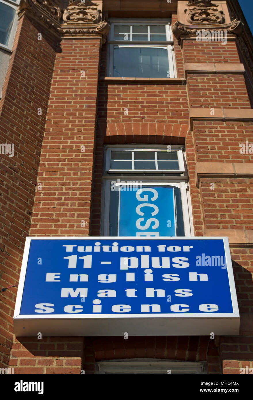 Die Studiengebühren für 11 plus Englisch, Mathematik und Naturwissenschaften, Werbung auf einem Gebäude in Hounslow, London, England Stockfoto
