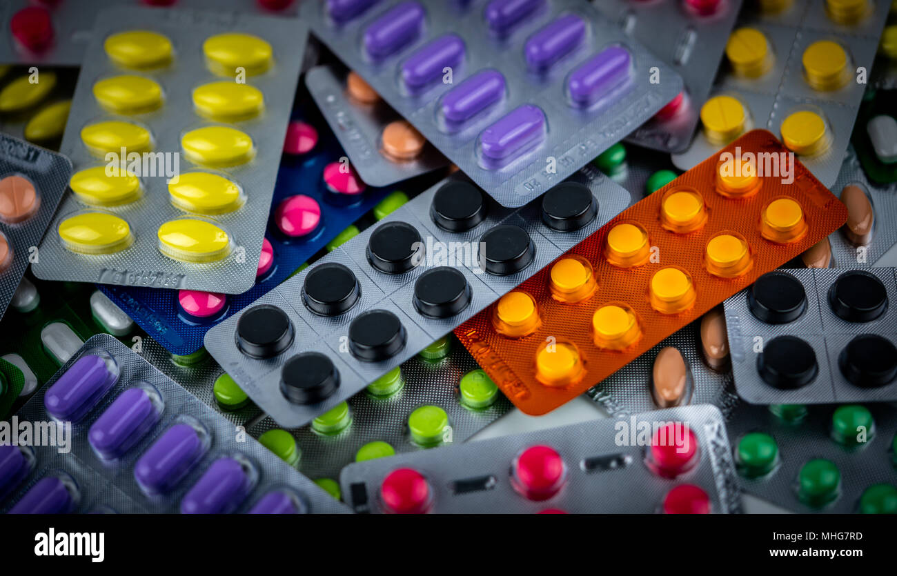 Stapel der Bunten tabletten Pille in Blisterverpackung. Pharmazeutische Industrie Konzept. Apotheke Apotheke. Schmerzmittel und Wechselwirkungen mit charcoa Stockfoto