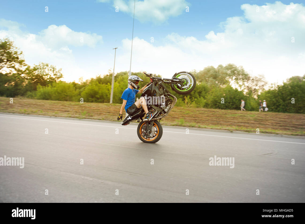 Ternopil, Ukraine - 9. August 2015: Stuntsman reiten schnell auf ein Rad entlang der Straße. Die gefährlichen Stunt. Fearless stuntsman tragen zum Schutz Helm. Stockfoto