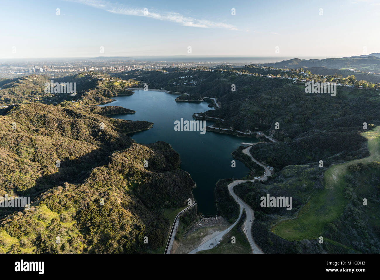 Luftaufnahme von Stone Canyon Reservoir und der Santa Monica Mountains mit Los Angeles Century City Towers und pazifischen Küste im Hintergrund. Stockfoto