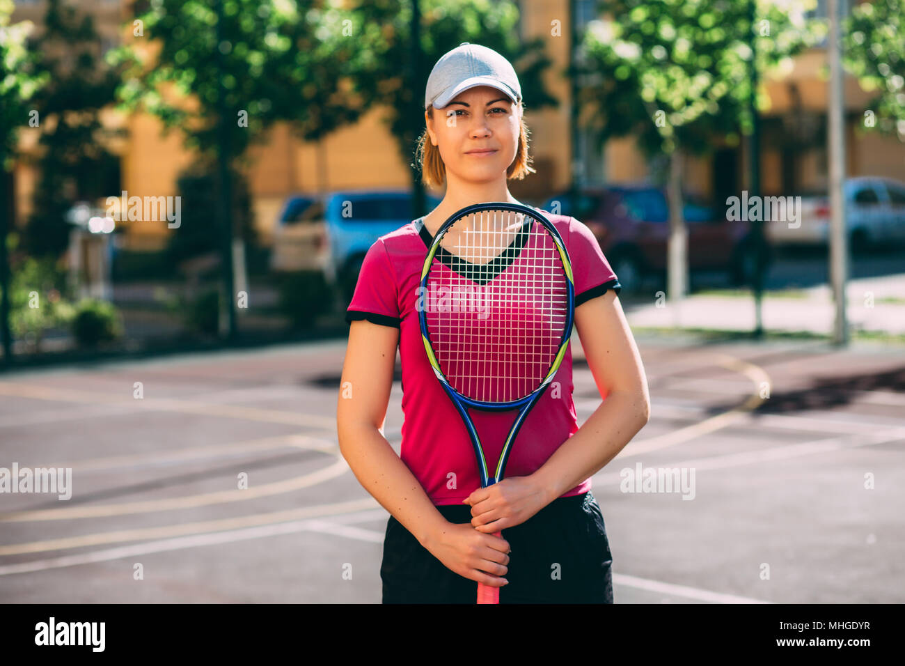 Porträt einer Frau mit einem Tennisschläger in der Hand, stand auf einem Tennisplatz. Tennis, Outdoor Stockfoto