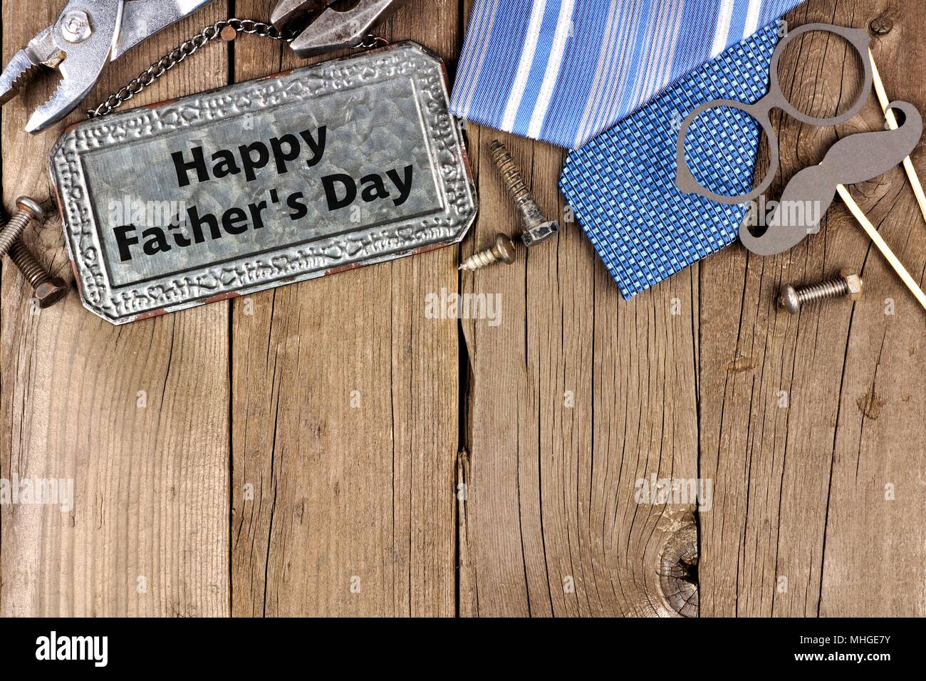 Happy Vatertag Nachricht auf Metall Schild mit oberer Rand von Werkzeugen und Beziehungen auf einer hölzernen Hintergrund Stockfoto