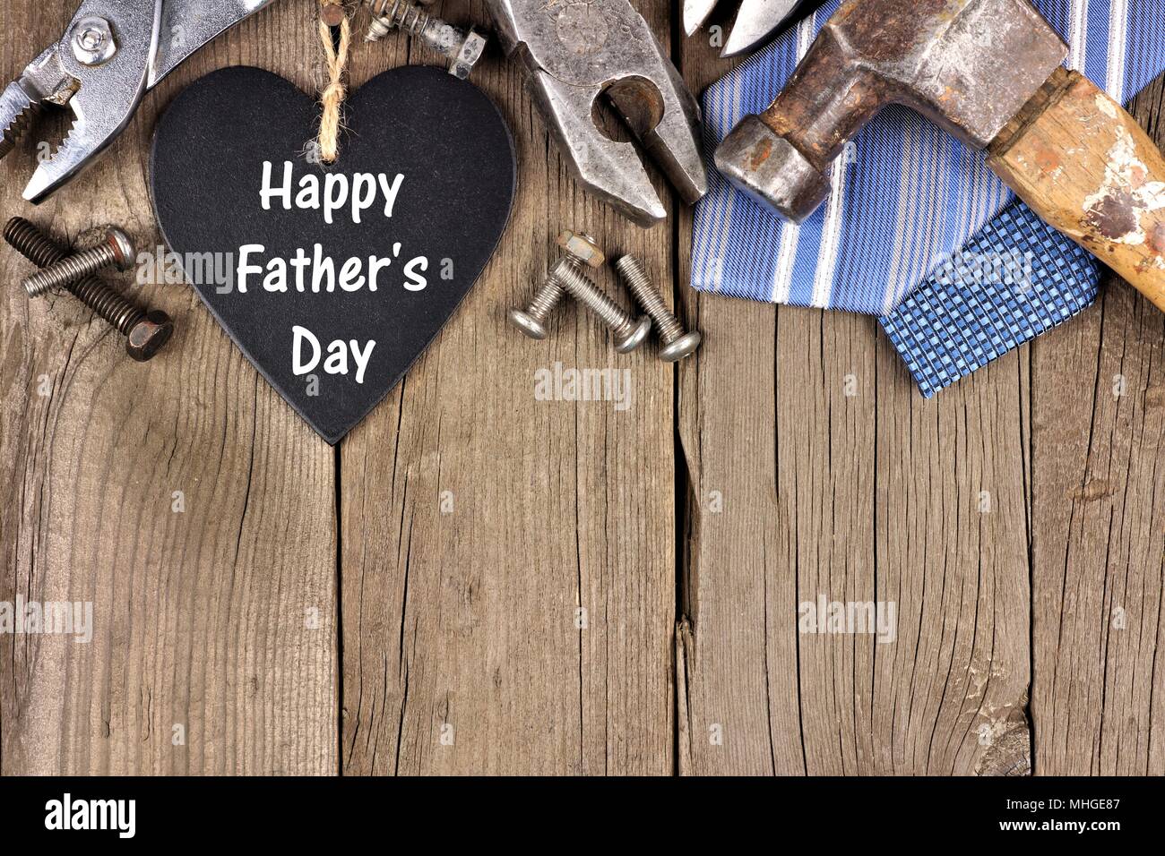 Happy Vatertag Schiefertafel Herz mit oberer Rand von Werkzeugen und Beziehungen auf einer hölzernen Hintergrund Stockfoto