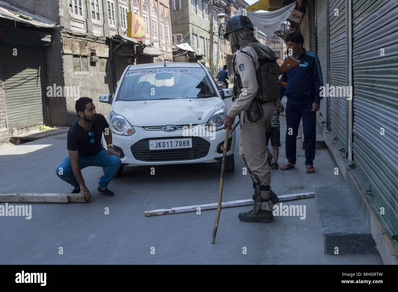 Mai 1, 2018 - Srinagar, Jammu und Kaschmir, Indien - Indische Para militärs troopers halt ein Fahrzeug als Kaschmir muslimischen Mann versucht den Baumstämmen von indischen Truppen während Beschränkungen in der Innenstadt von Srinagar Stadt verteilt zu entfernen, Sommer Hauptstadt von Jammu und Kaschmir. Die indischen Behörden am Dienstag auferlegten Beschränkungen in vielen Teilen von Srinagar Stadt Unruhen und Proteste in das Tal nach einem Protest durch JRL (gemeinsamen Widerstand Führung) gegen Tötung von student Shahid Ashraf dar und zwei lokale Rebellen Sameer Ahmad und Aqib Wani von indischen Streitkräfte und verletzen mehr Th verhindern Stockfoto