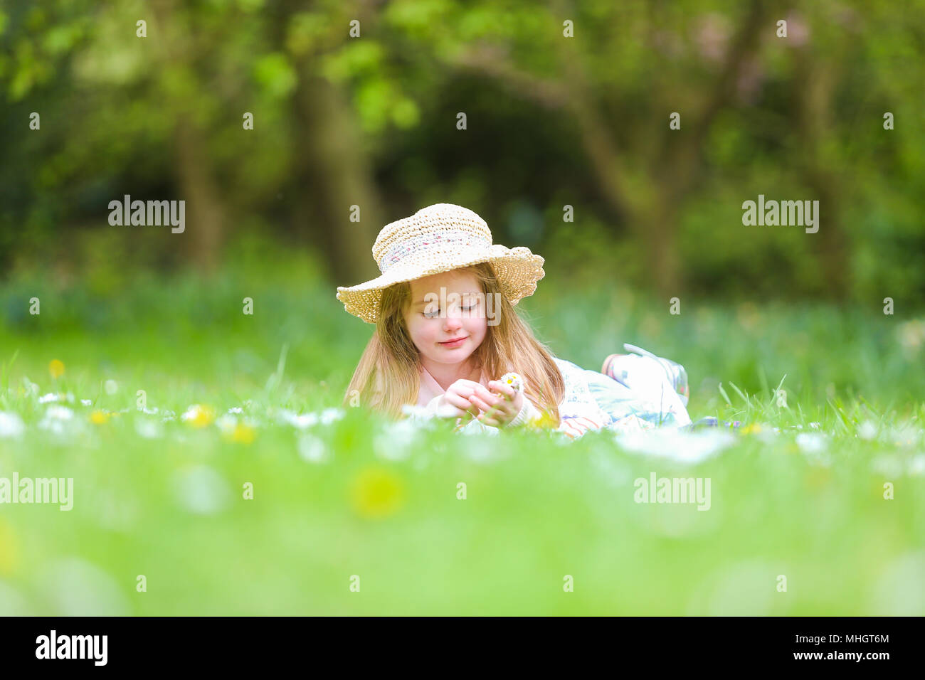 4-jähriges Mädchen im Park im Frühling, die auf dem Gras Stockfoto