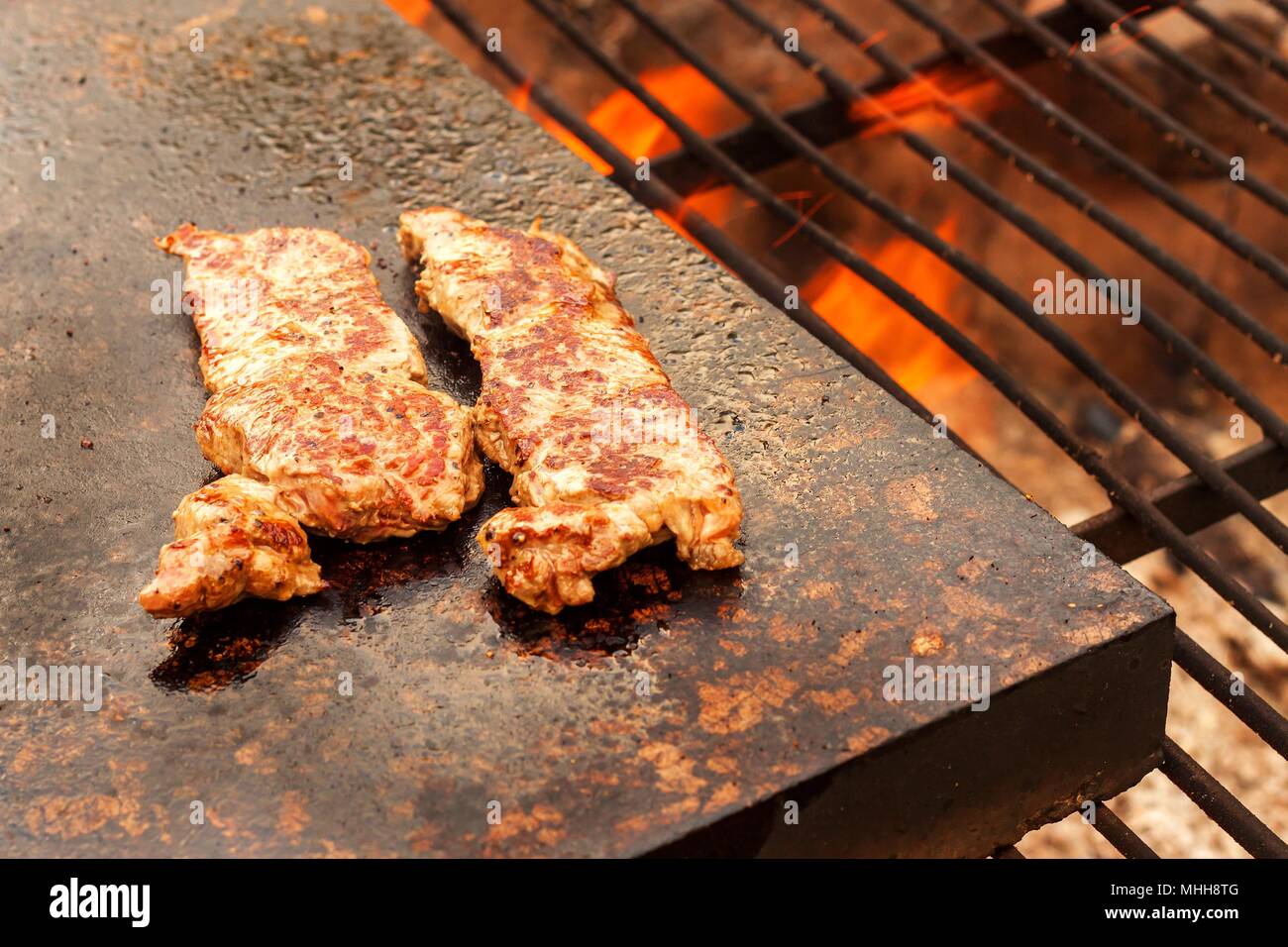 Grillen beef steak auf einer Granitplatte. Zubereitung von Fleisch auf  Feuer. Sommer Grill Stockfotografie - Alamy