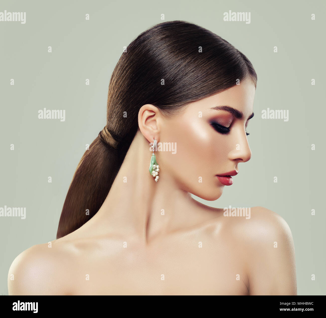Fashion Model Frau mit Make-up, gesunde Haare und Ohrringe mit Perlen und  Schmuck grüne Juwel Stockfotografie - Alamy
