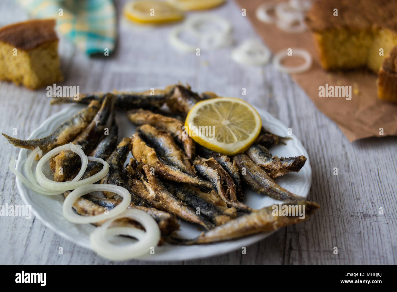 Türkische Hamsi Tava mit Cornbread/Frittierte Sardellen auf weißem Holz- Oberfläche. Stockfoto