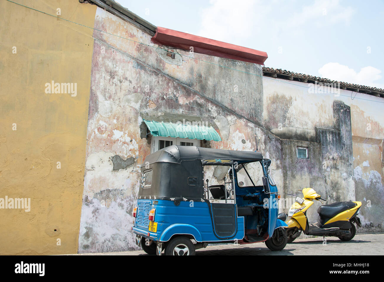 Galle, Sri Lanka: Galle Fort Straßenbild. Typische Architektur, bunte Stuck Wand, mit Tuk-Tuk und Motorroller im Vordergrund Stockfoto
