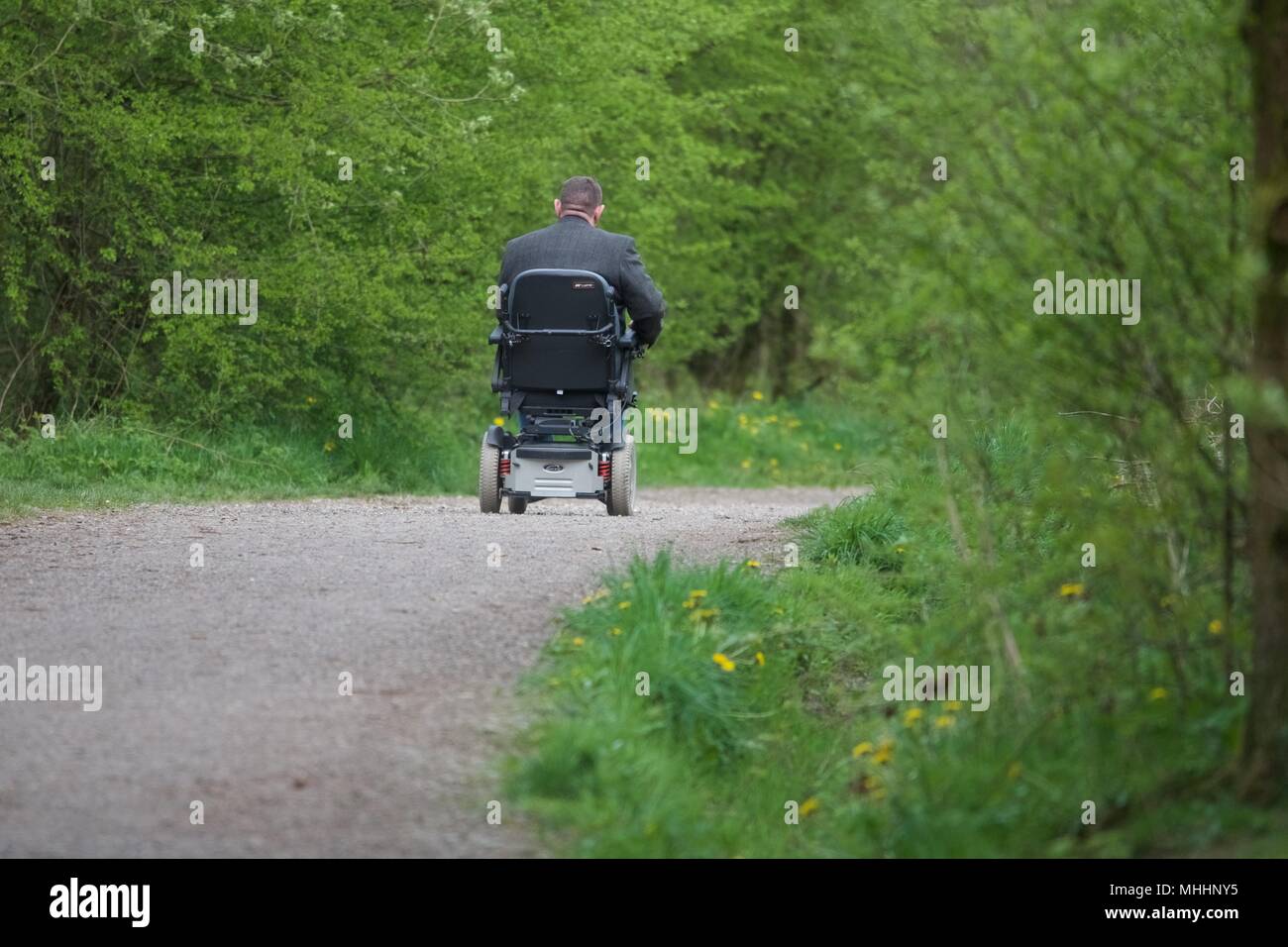 Ein Mann in einem elektrischen Rollstuhl fährt die Sett Valley Trail in neuen Mühlen, Derbyshire. Stockfoto