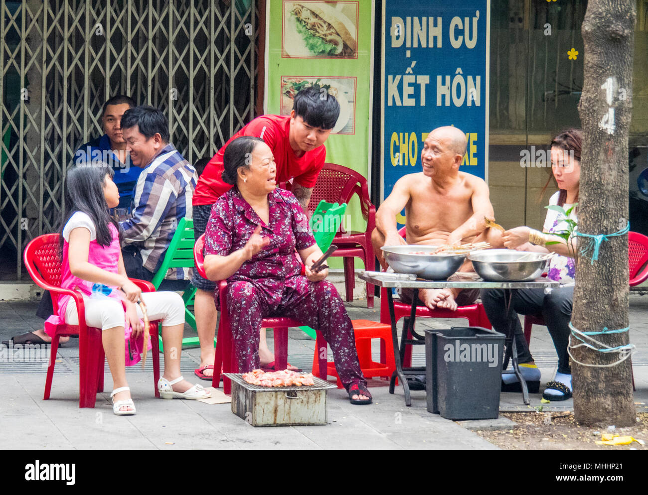 Eine Familie von Straßenhändlern die Zubereitung von Speisen für den Verkauf auf der Straße im District 1, Ho Chi Minh City, Vietnam. Stockfoto