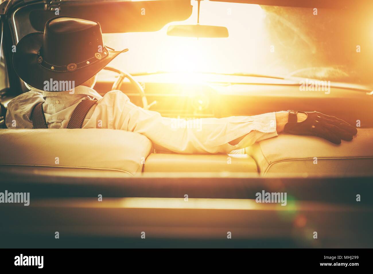 Die Sun Road. Western Wear Männer in Cowboy Hut fahren Classic Cabrio. American Dream Retro Stil Konzept. Stockfoto