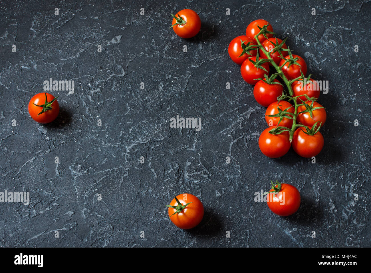 Frische Kirschtomaten auf Stein. Ökologische Lebensmittel. Platz für Text. Stockfoto