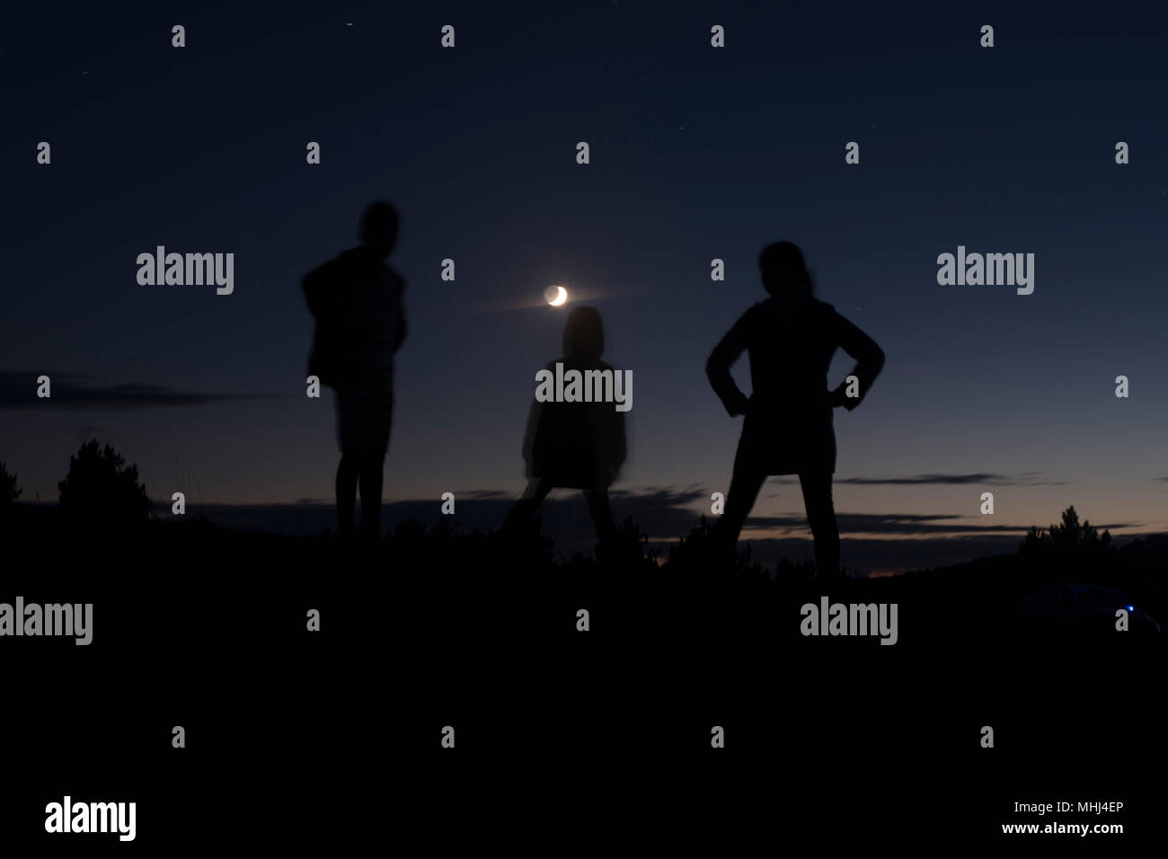 Konturen von drei Menschen bei Nacht Stockfoto