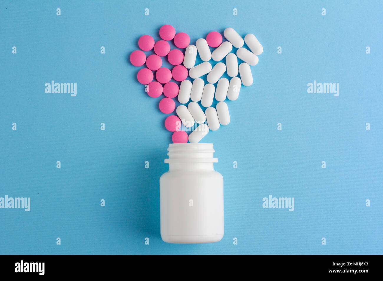 Herzen der sortierten Pillen auf Pastell-blaue Hintergrund. Flach Stockfoto
