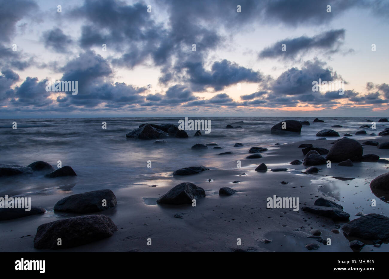 Eine Marine in der Dämmerung mit großen dunklen Steine auf einen leeren Strand in der Nähe von Kaltene, Lettland. Stockfoto