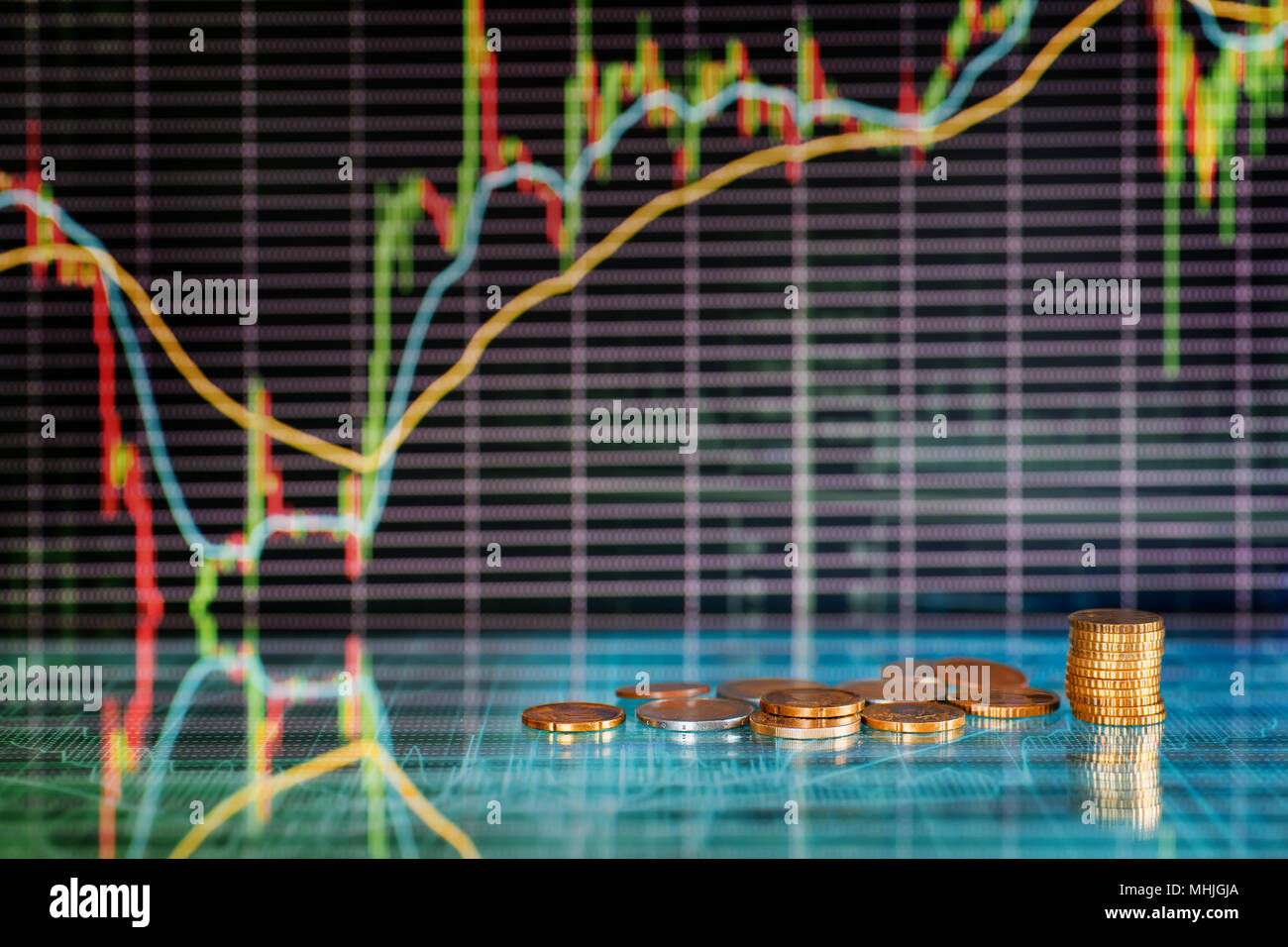 Geld und Börse Diagramme. Münzen gegen futuristische Display mit Kerzen Diagramme Stockfoto