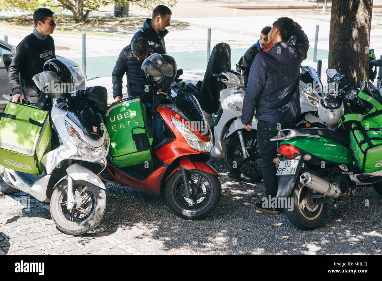 Portugal, Lissabon, 29. April 2018: Arbeitnehmer Uber isst auf dem Roller die Lebensmittel an die Kunden. Stockfoto