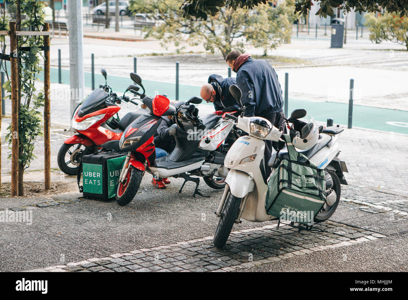 Portugal, Lissabon, 29. April 2018: Arbeitnehmer uber Isst delivery Roller mit Koffer Stockfoto