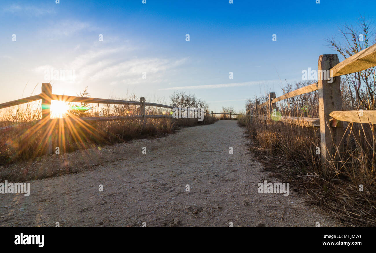 Holzzaun führt zum Strand in der Nähe von Leuchtturm in Cape May, NJ, an einem sonnigen Morgen Stockfoto