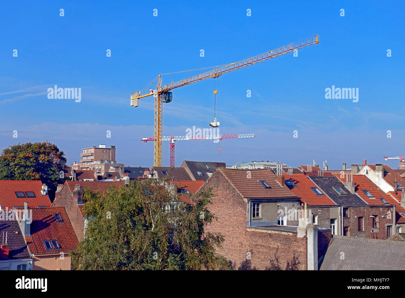 Verschieben einer großen Kran in die dicht gedrängten Häuser im Brüsseler Stadtteil Ixelles, Belgien überspringen Stockfoto