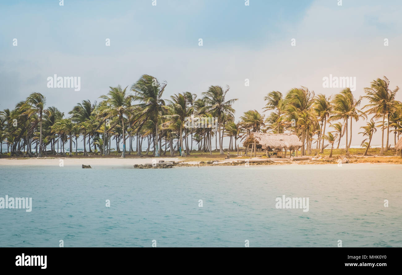 Wunderschöne Insel Strand mit Palmen und strohgedeckten Hütten an der Küste Stockfoto