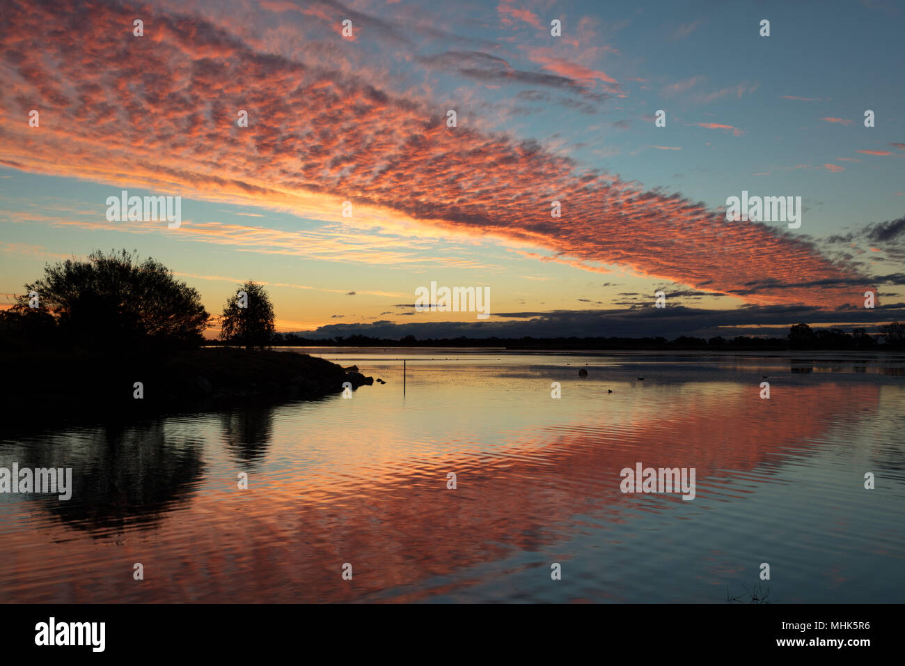 Condobolin, New South Wales, Australien. Leuchtende Wolken und Reflexionen bei Sonnenuntergang bei Gum Bend See in Condobolin im Südwesten von New South Wales. Stockfoto