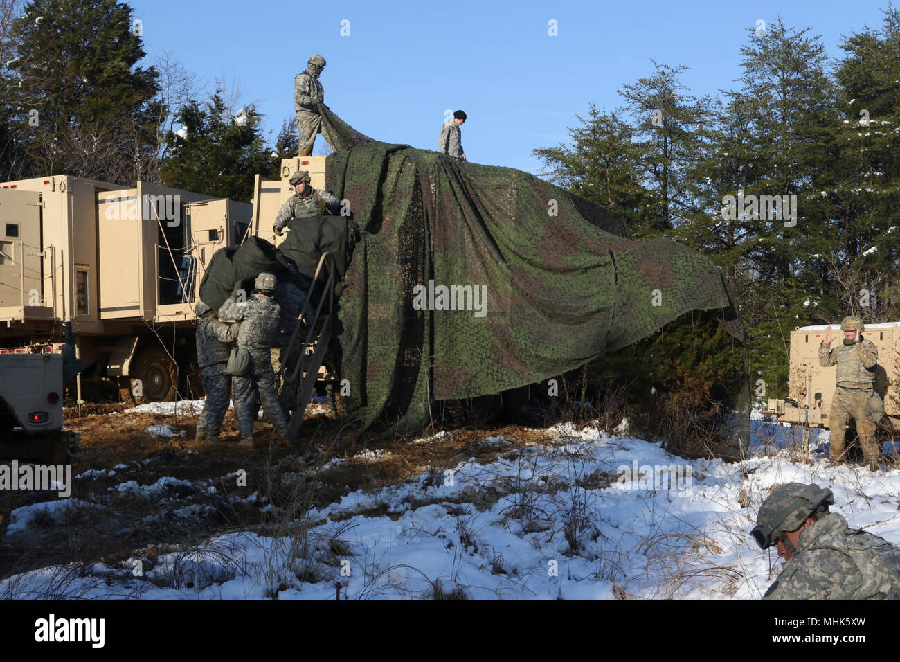 U.S. Army Reserve Soldaten, die in den 364 Expeditionary Sustainment Command ein tarnnetz über Springen Tactical Operations Center Coyote in Fort Knox, Ky., 22. März 2018, während der Kombinierten Situationstraining Übung - Brücke zu verbergen. Der Sprung TOC-Fähigkeit der 364 ESC demonstriert sustainment Operationen von einem mobilen Umgebung durchführen. Stockfoto