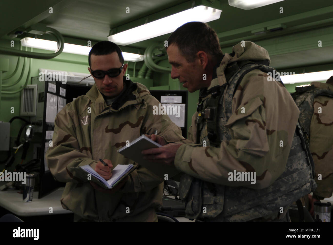 Chief Warrant Officer 3 Luis Castillo, ein multi-Klasse Commodity Manager mit der 364 Expeditionary Sustainment Command, und Chief Warrant Officer 3 Darin, Transport und Mobilität Chief mit dem 364 th, Überprüfen der Notizen zu springen Tactical Operations Center Coyote in Fort Knox, Ky., 22. März 2018, während der Kombinierten Situationstraining Übung - Brücke. Der Sprung TOC-Fähigkeit der 364 ESC demonstriert sustainment Operationen von einem mobilen Umgebung durchführen. Stockfoto