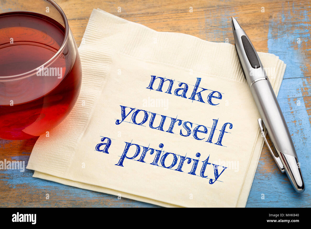 Machen Sie sich eine Priorität Beratung - Handschrift auf eine Serviette mit einer Tasse Tee Stockfoto
