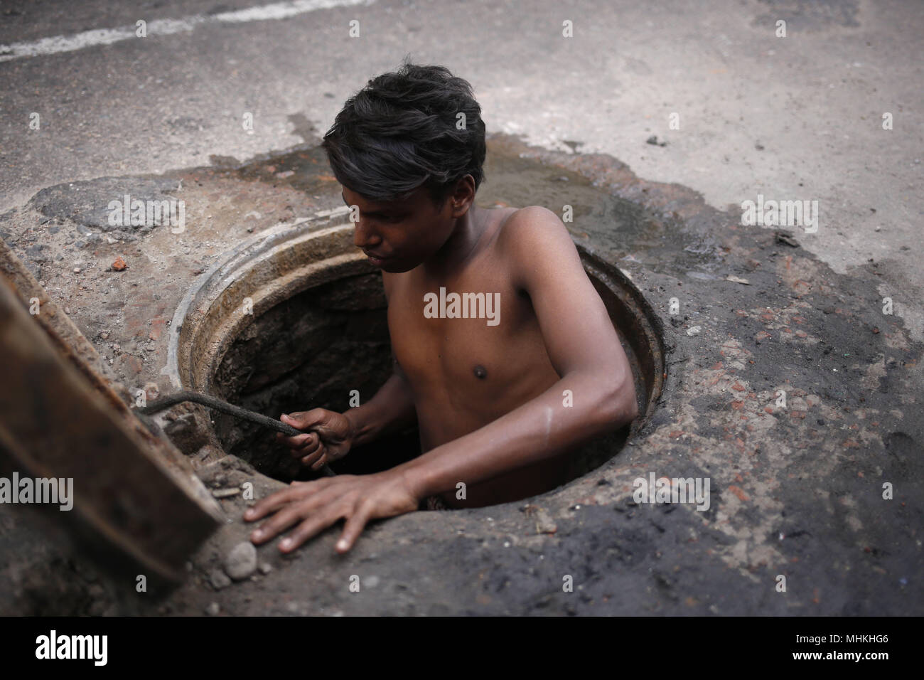 Dhaka, Bangladesch. Zum 2. Mai, 2018. Sumon (14), ein Kind Abwasserkanal cleaner von Dhaka, der Hauptstadt von Wasa (Dhaka Wasserversorgung und Kanalisation Behörde), die Reinigung von Schlamm und Müll aus einem Mannloch ohne Sicherheitsausrüstung Dhaka. Er verdienen 6 $ pro Tag für diese schlimmste Job. Für die fehlende Sicherheit Ausrüstung Tod jedes Jahr der Kanalisation Reiniger in der Hauptstadt. Quelle: Md. mehedi Hasan/ZUMA Draht/Alamy leben Nachrichten Stockfoto