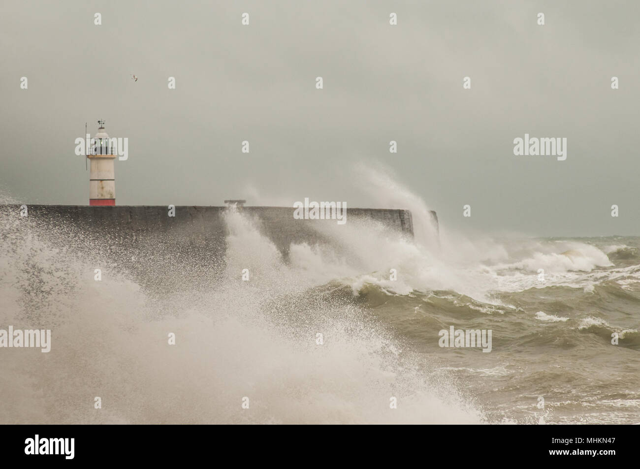 Newhaven, East Sussex, UK..2. Mai 2018. Großbritannien Wetter: Heller später am Tag nach dunklen Wolken & Regen peitscht starker Wind die Brandung am Hafen West Break Water an, bevor er endlich abatscht. Stockfoto