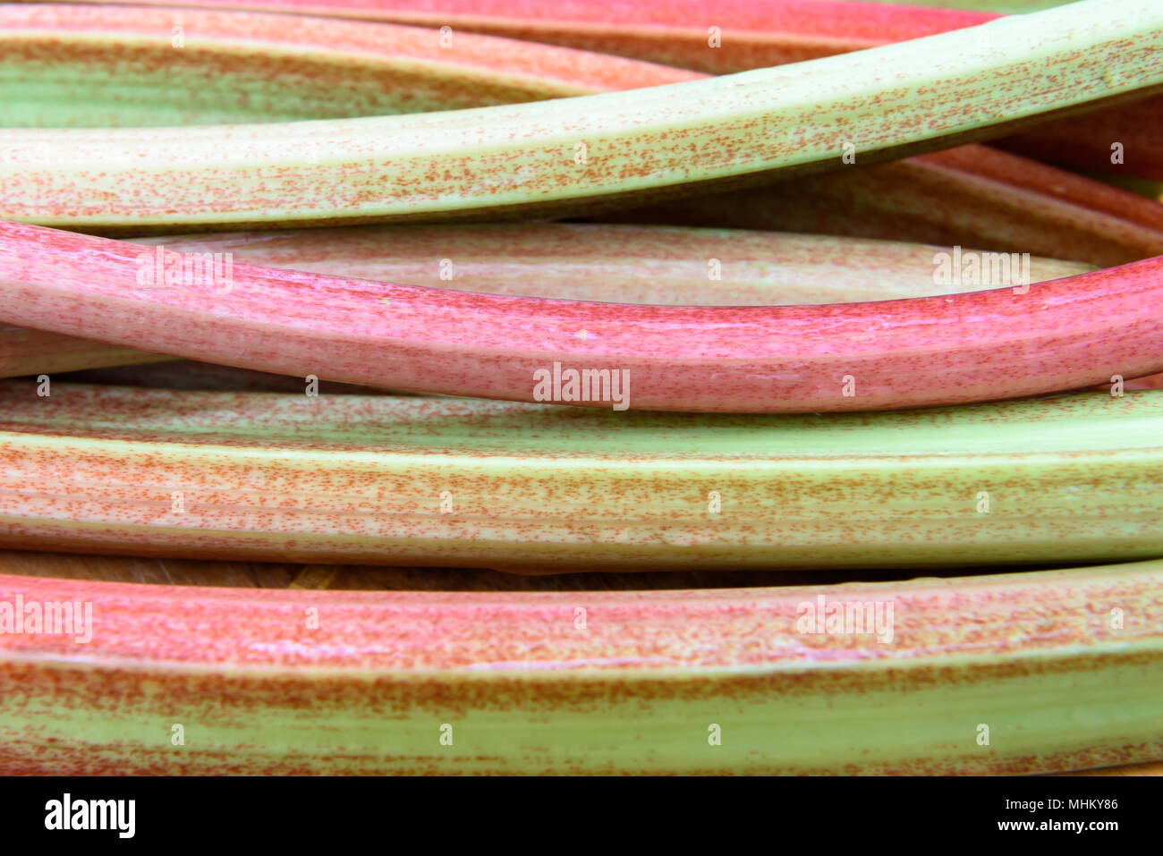 Frische rohe Rhabarber Früchte mit braunen Hintergrund Stockfoto